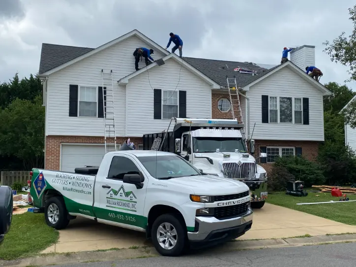 William Richmond trucks in front of a house where a new roof is being installed